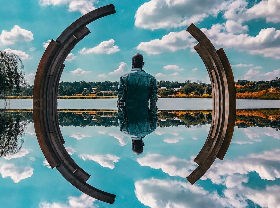 photoshopped image of a man standing in water with his reflection being seen in the water